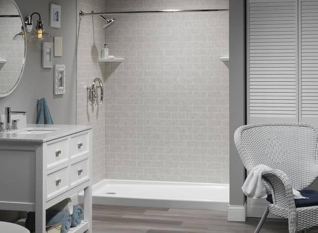 bathroom shower with white tile, vanity and chair