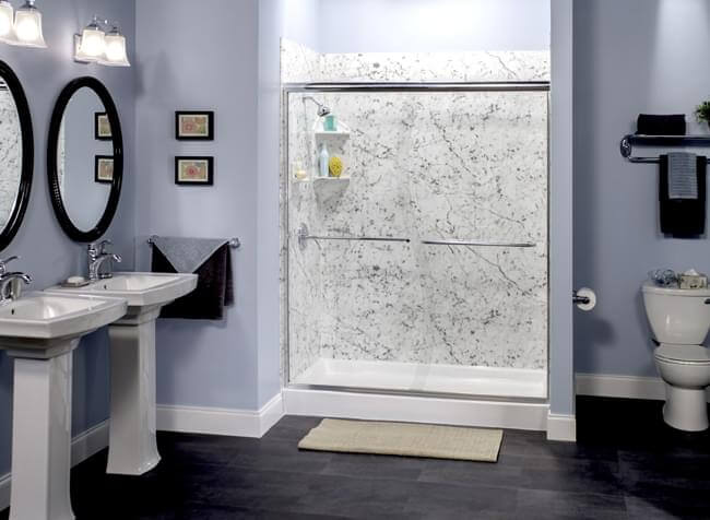 sliding glass door on bathroom shower with dual vanities and toilet