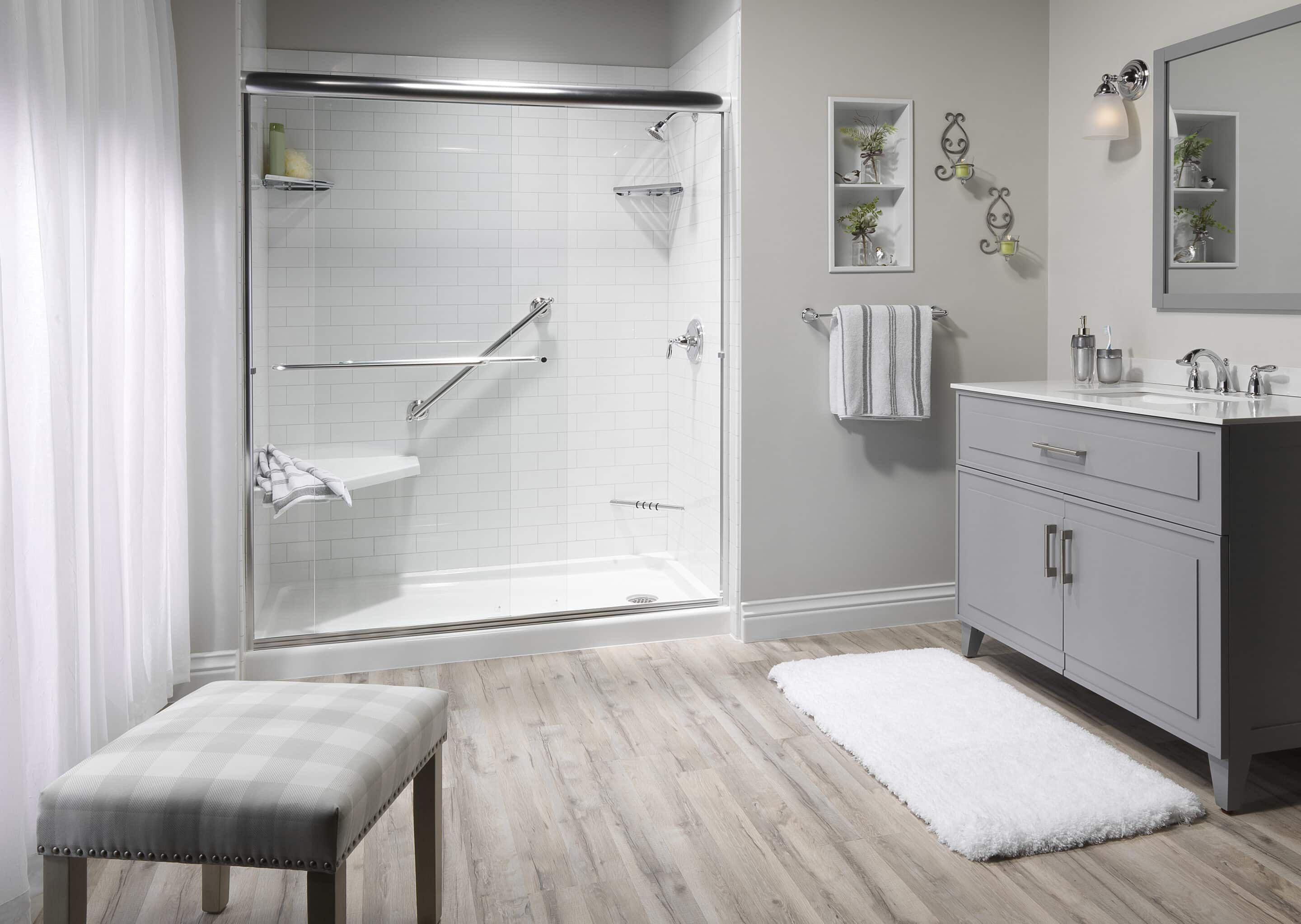 a bathroom with a glass shower and a white rug