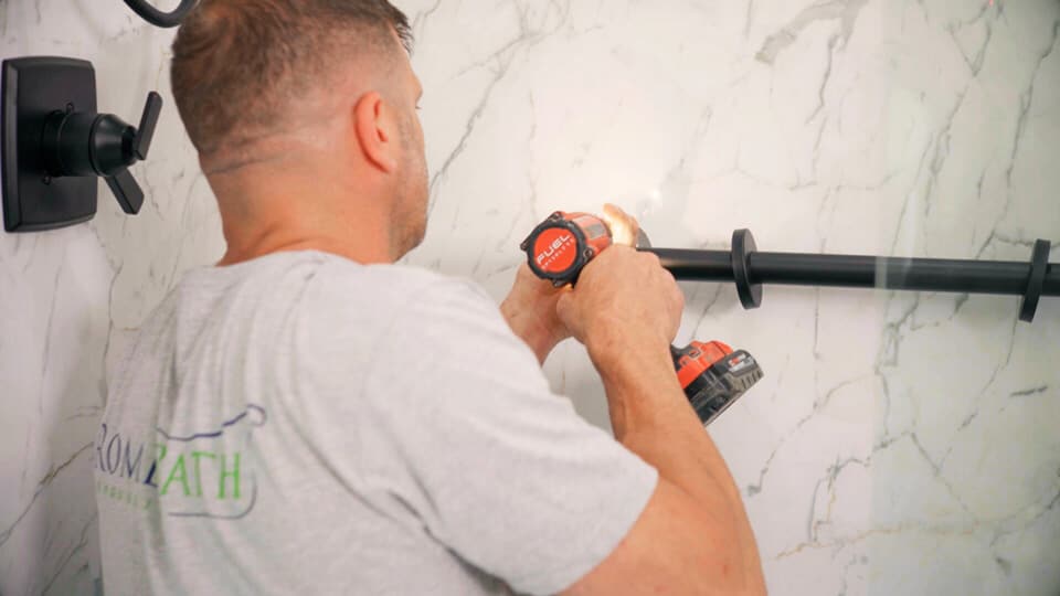 bathroom remodel employee installing safety railings in a shower
