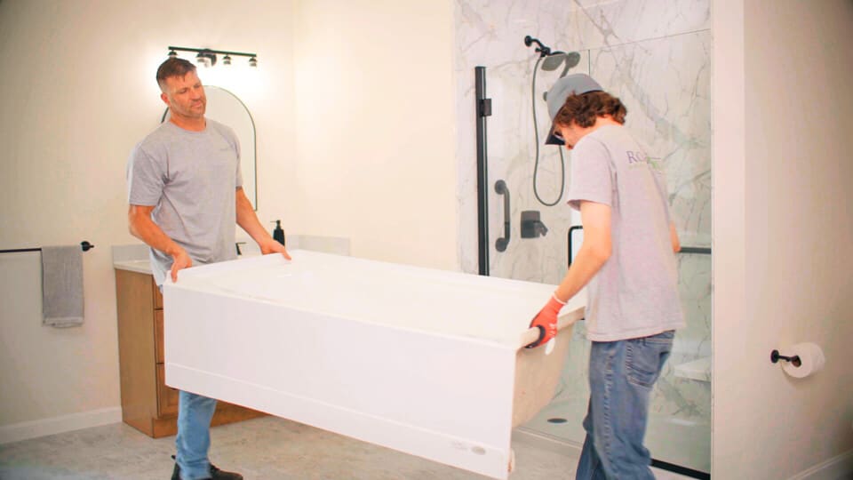 two installers placing a new bathroom remodel
