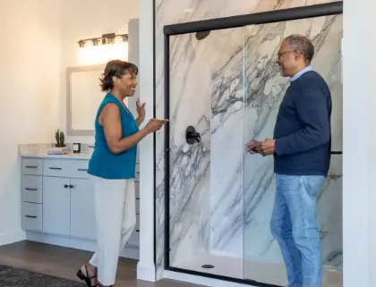 Couple looking at a porcelain tile walk-in shower in the Rome Bath Remodeling showroom