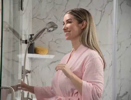 Woman in pink robe checking out her new walk-in shower
