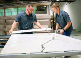 two employees measuring and cutting large format porcelain tile wall surround