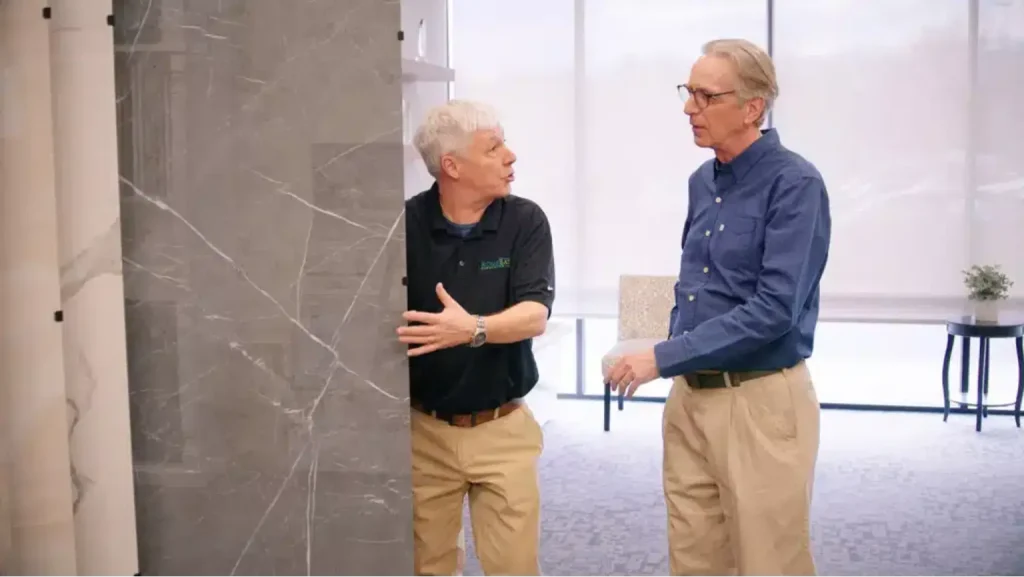 rome bath remodeling design team employee showing a customer the advantages of large format italian porcelain tile on display