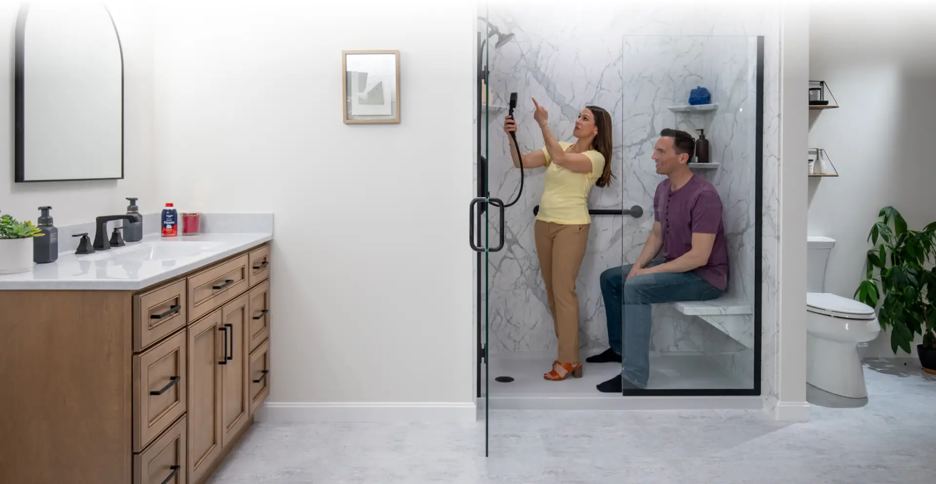 two customers exploring the different bathroom features at the rome bath remodeling showroom