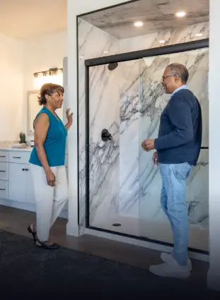 Couple looking at a porcelain tile walk-in shower in the Rome Bath Remodeling showroom