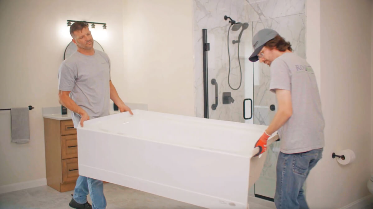 two rome bath employees moving a bath tub for install