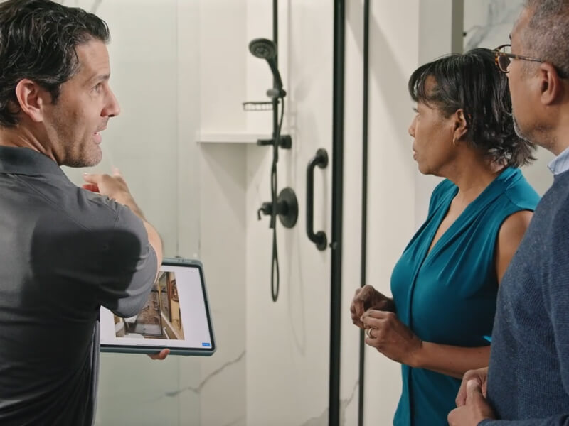 bathroom remodeling employee showcasing design tools and bathroom remodeling options