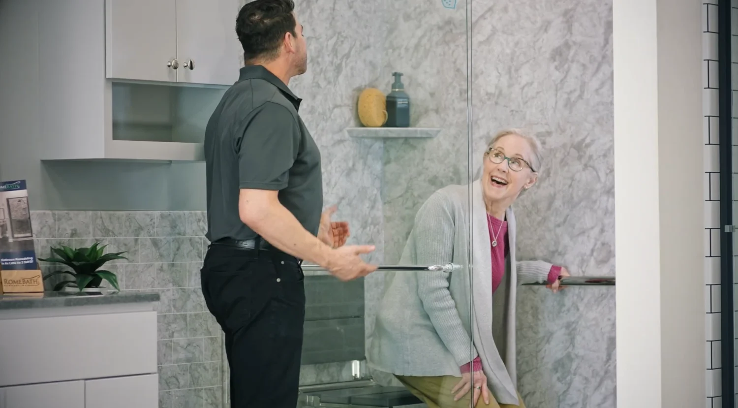 rome bath employee helping woman explore the safety features within bathroom remodels